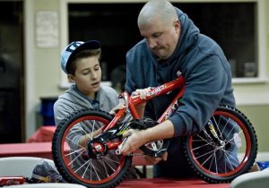 Shawn Lucas and son, Matthew, build a bike that will be donated to an area child for Christmas.
